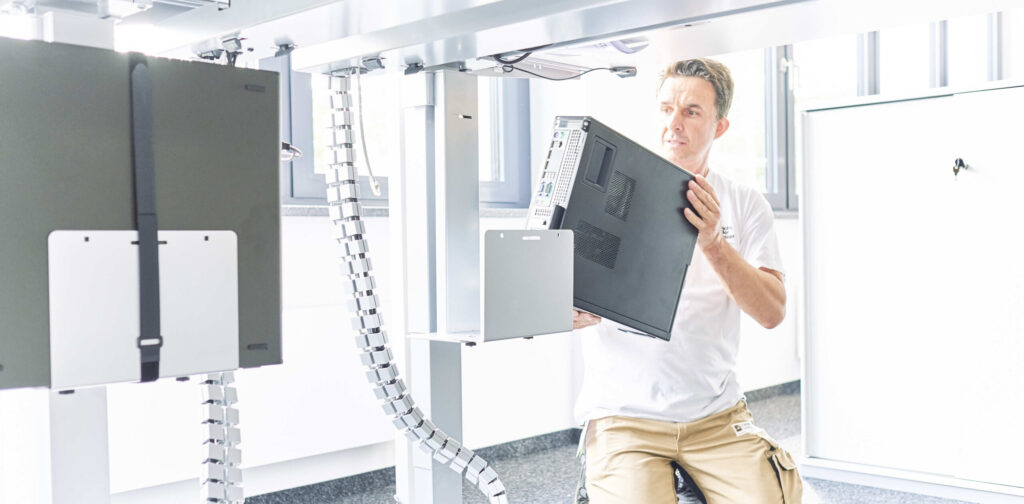 Derichsweiler Mitarbeiter installiert einen Computertower.